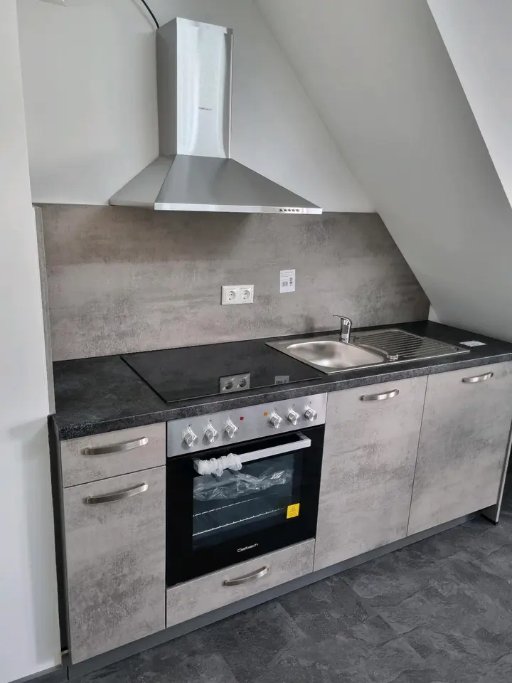 Moderne Küche mit passgenauen Schränken und einer Kochinsel aus Eichenholz